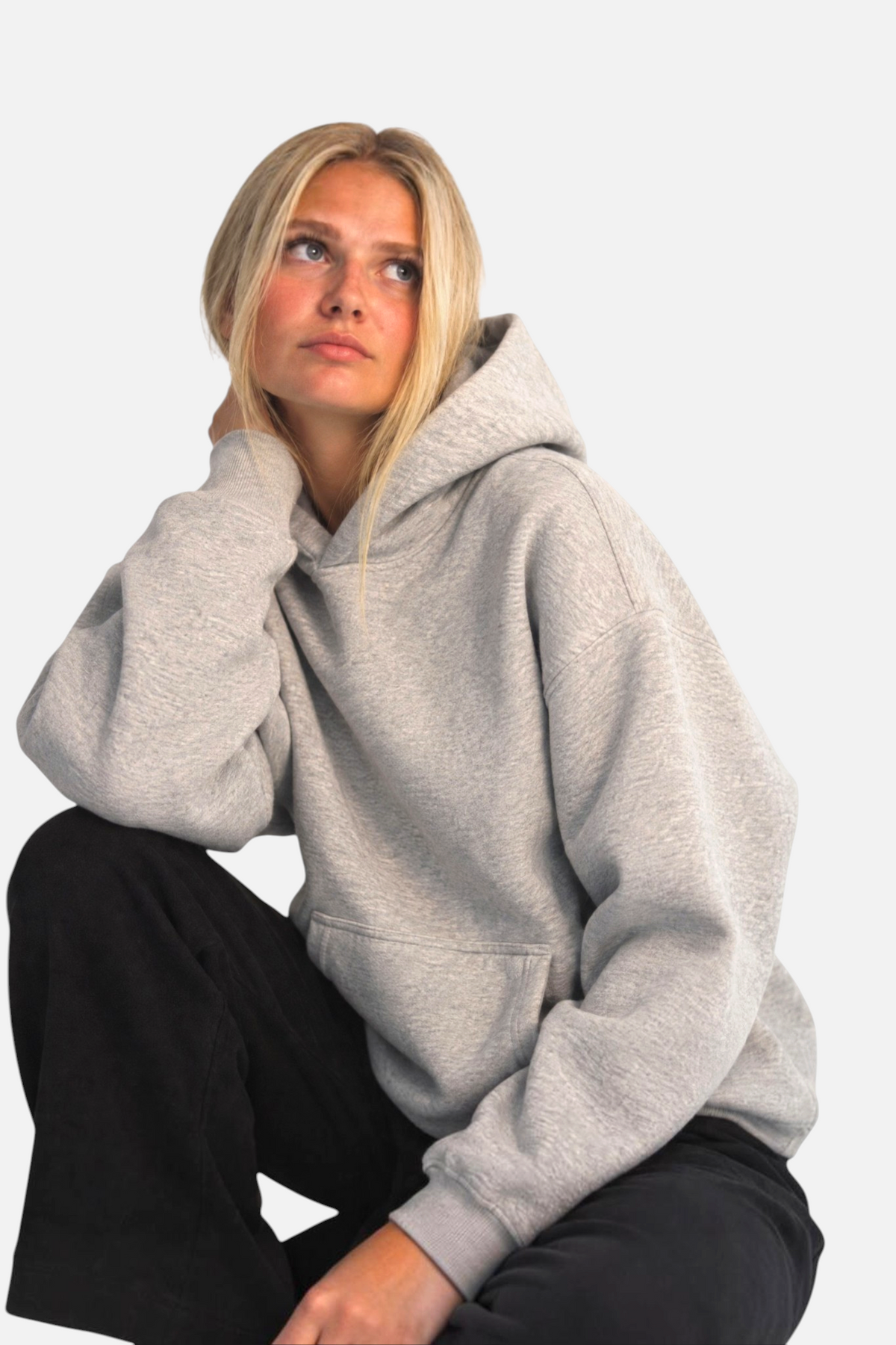 Model wearing a grey noora boxy fit brushed fleece hoodie with a front pocket and hood against a white background