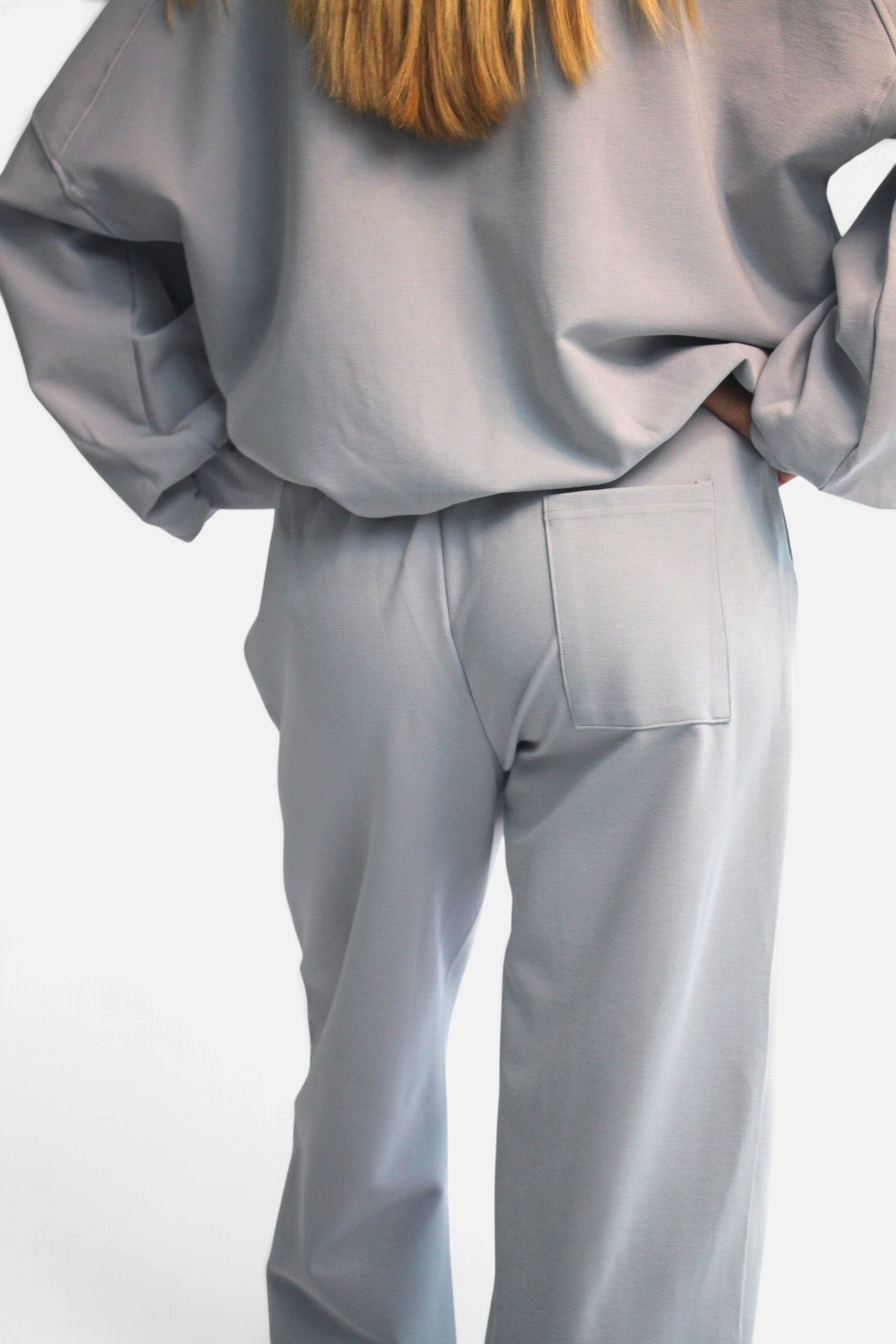 noora straight fit joggers in light grey cotton blend with back pocket, worn by a model from behind