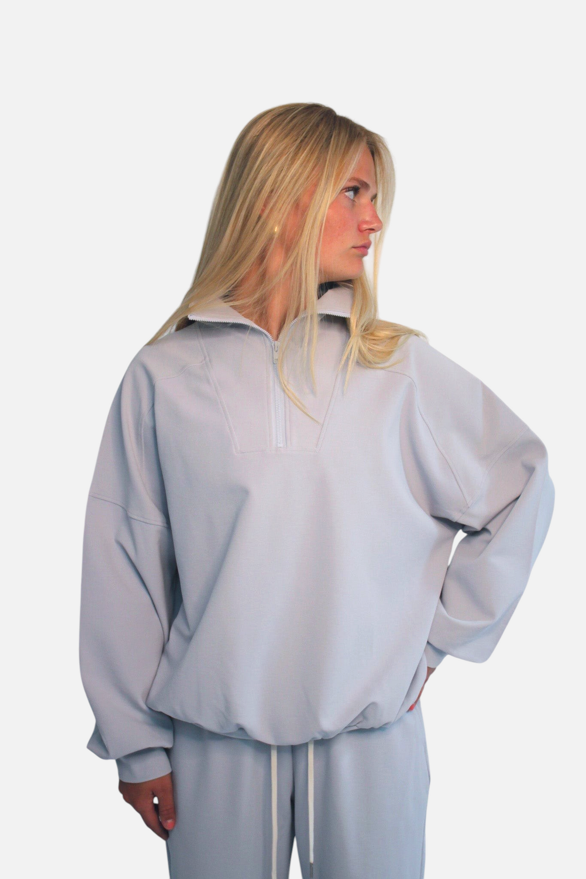 noora light grey 3/4 zip sweater with relaxed fit and crewneck worn by a blonde model against a white background