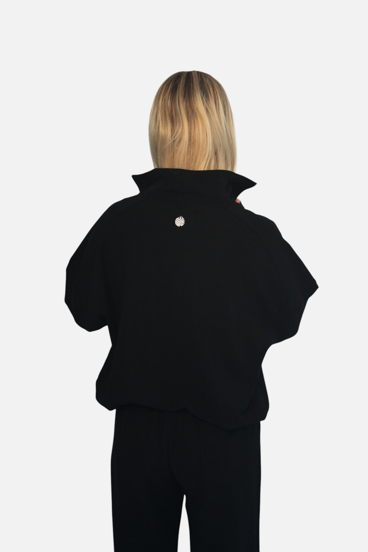 Back view of a blonde model wearing a black noora 3/4 zip cotton-blend sweater with a small logo on the upper back.