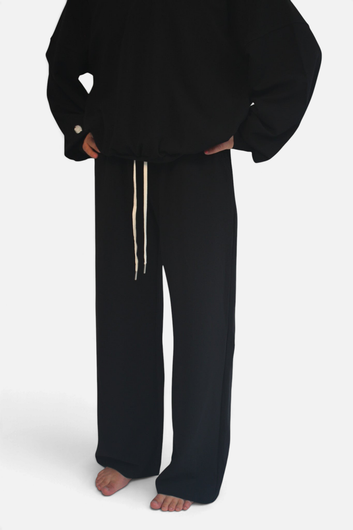 noora black straight fit joggers with an adjustable white drawstring waistband worn by a model
