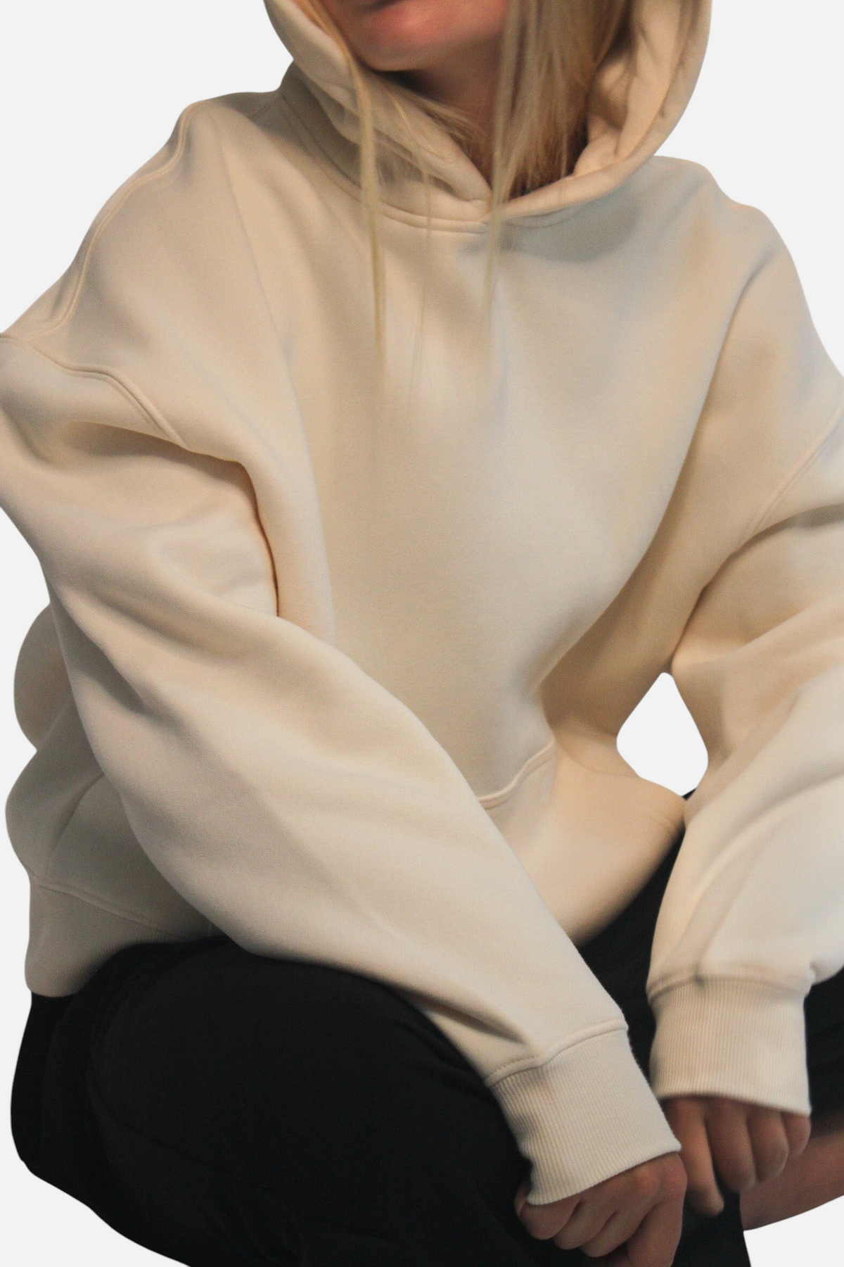 noora Soft Hoodie in cream brushed fleece with a boxy fit, hood, and front pocket worn by a model